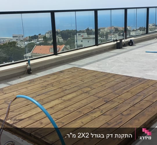 משטח עץ על מרפסת עם צינורות כחולים